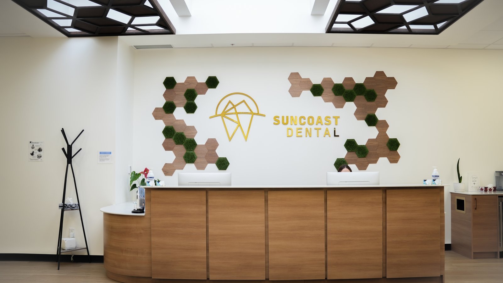 Dental team consulting with a patient in a treatment room at Suncoast Dental
